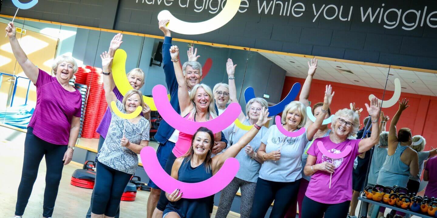 Group of women gym members smiling and waving