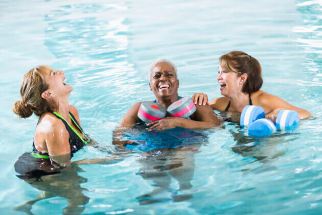 three women laughing in an aqua aerobics class