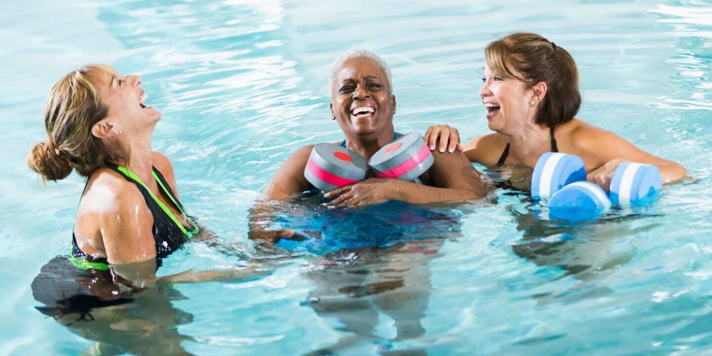 mature women in pool, laughing