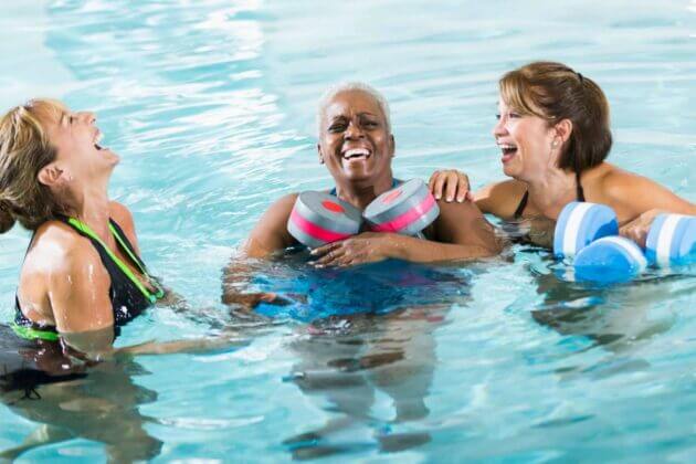 mature women in pool, laughing