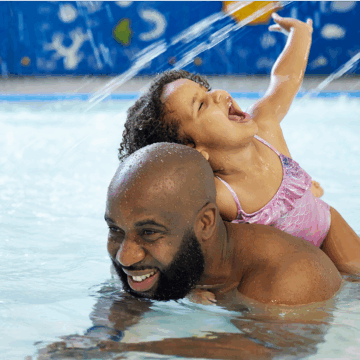 Adult and child having fun in the pool