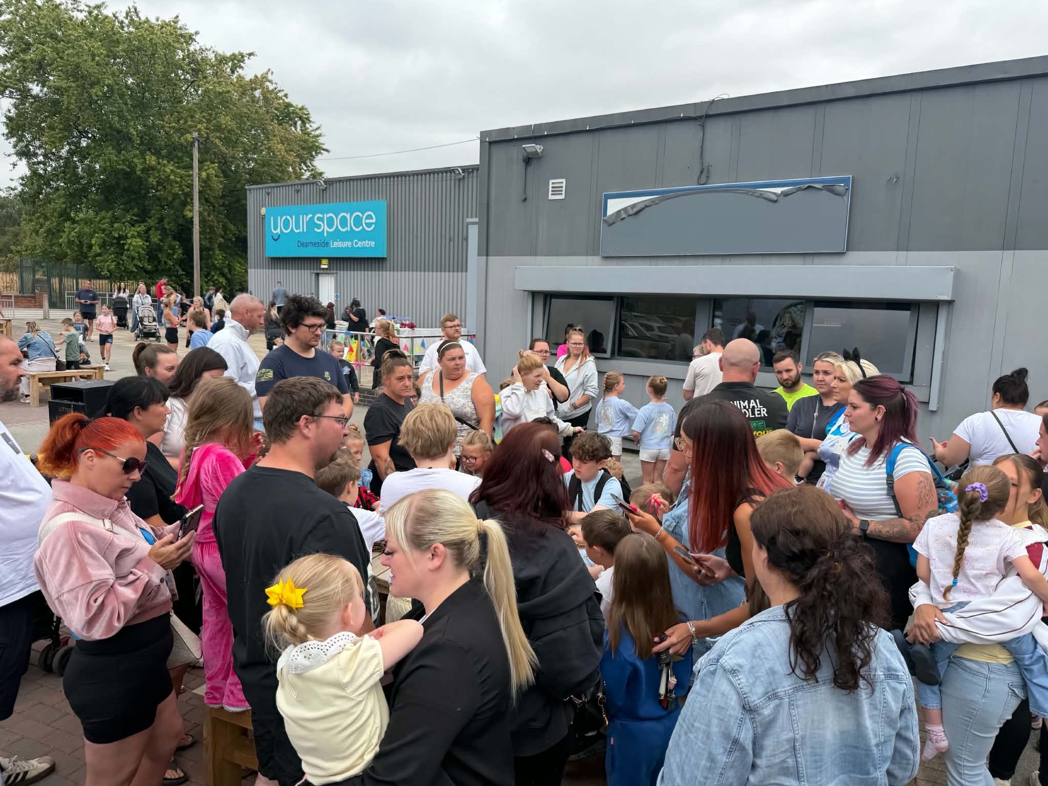 A large crowd of families gathered outside Your Space Dearneside