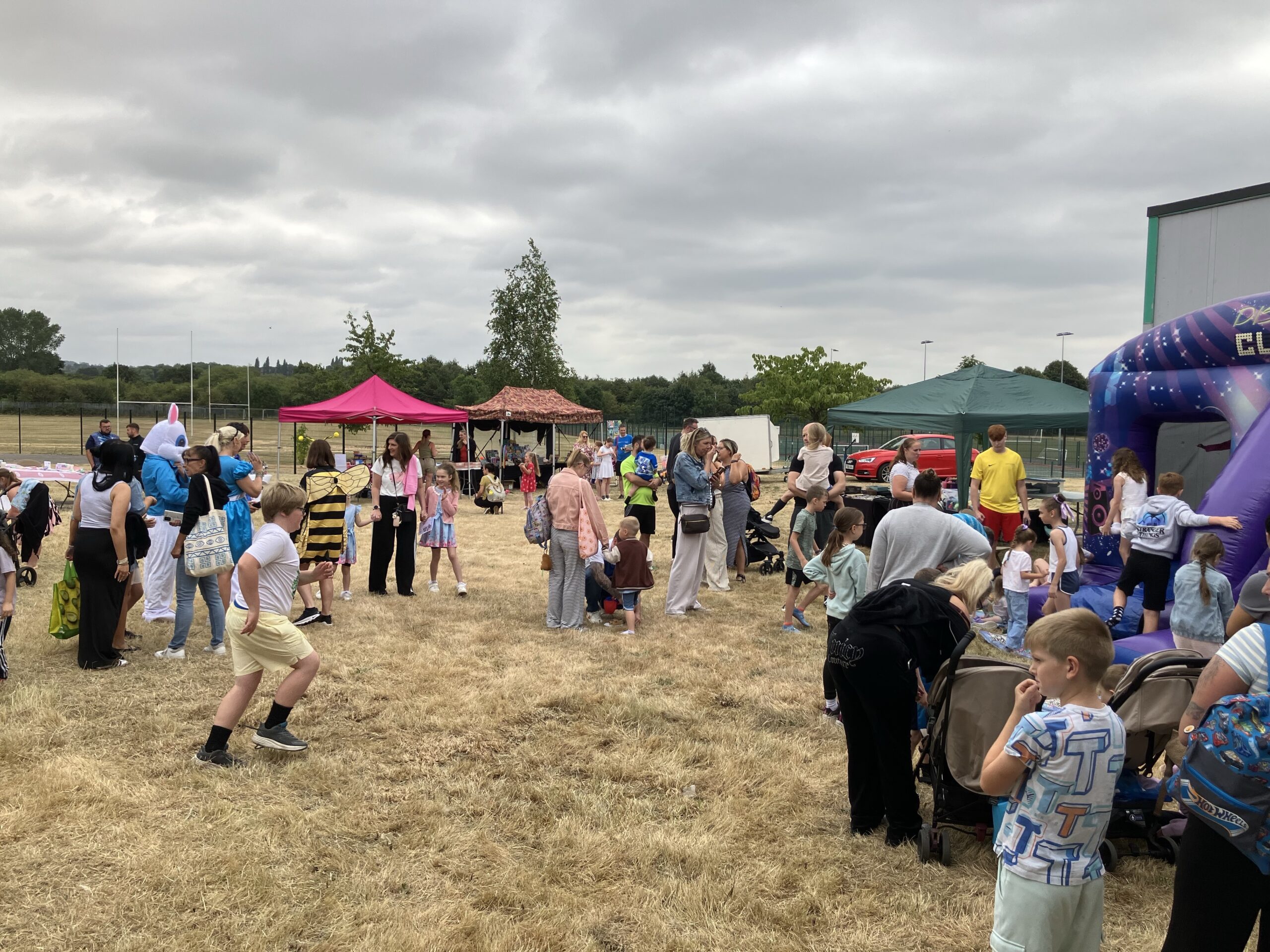 Families enjoying stalls and the bouncy castle at Your Space Dearneside